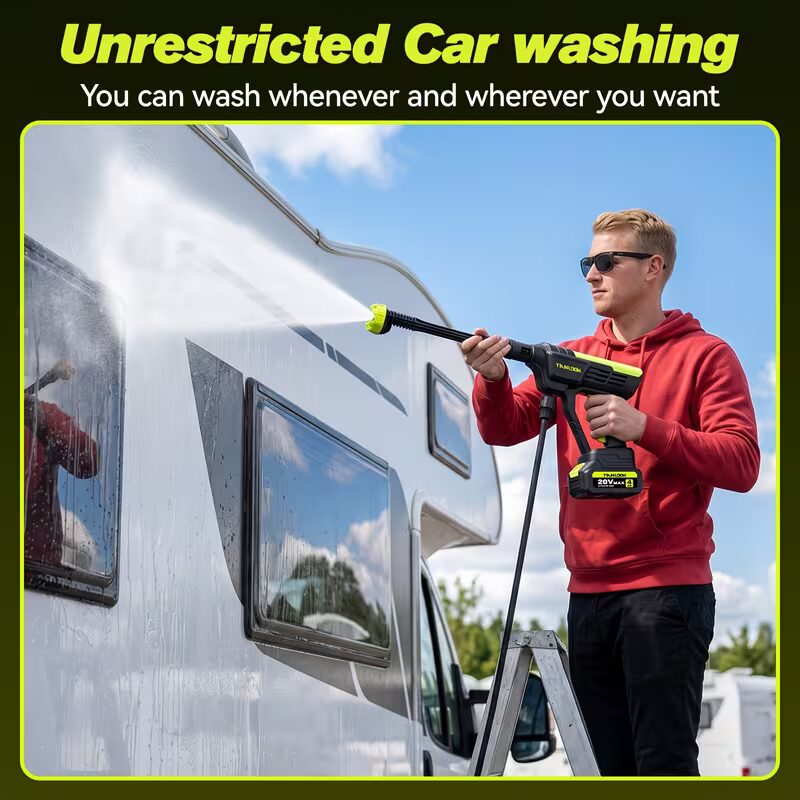Man using a wireless high-pressure car washer to clean the side of an RV camper van outdoors